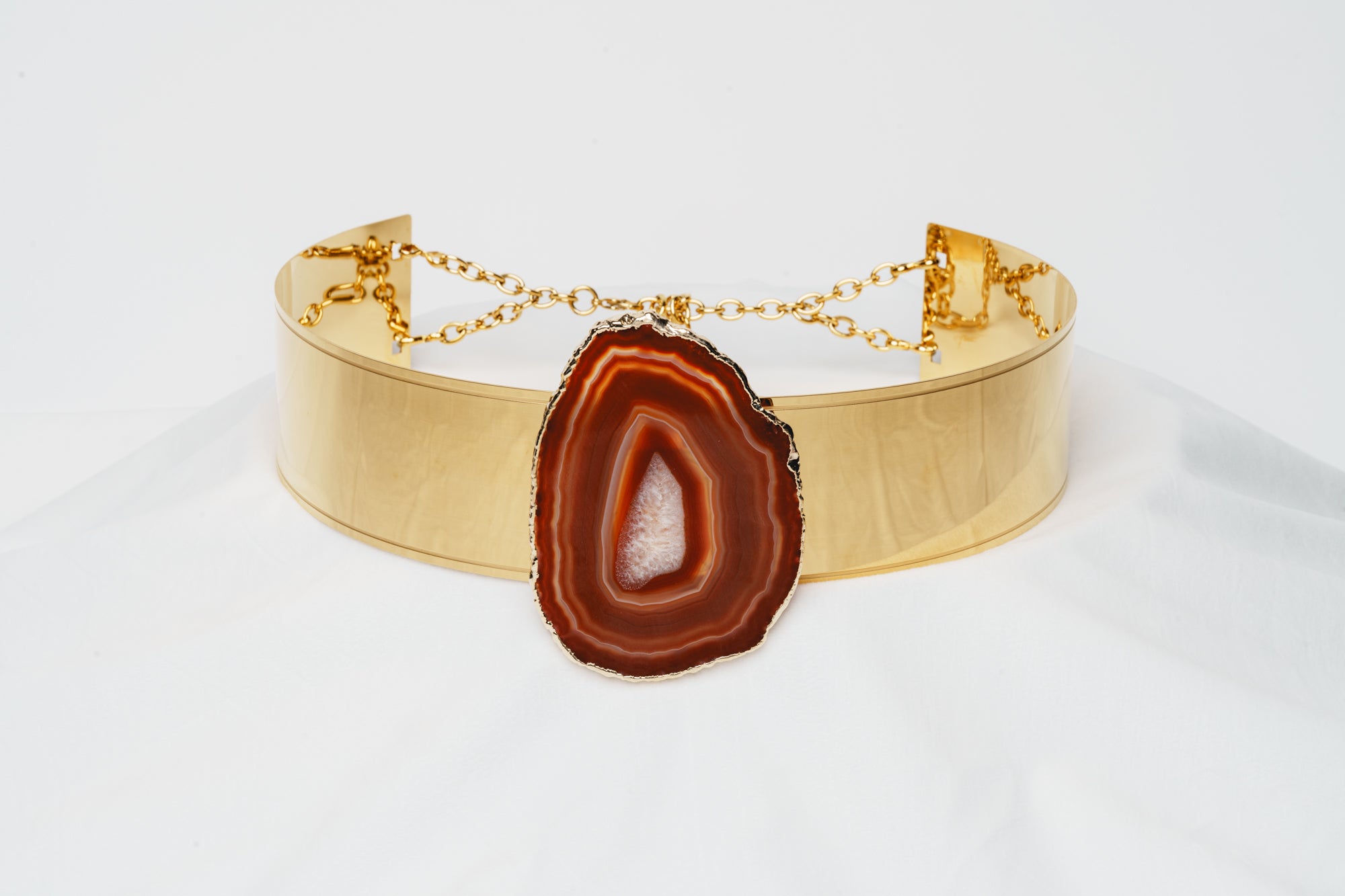 vue de face ceinture de pouvoir en métal plaqué or pendentif avec pierre agate orange rouge sanguine gemme prodigieuse fixée par magnétisme taille haute énergie boucle d'or paris coffret harmonie terrestre